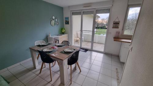 eine Küche mit einem Tisch und Stühlen im Zimmer in der Unterkunft Beau T2 bien équipé au calme! ! in Saint-Pierre-du-Mont
