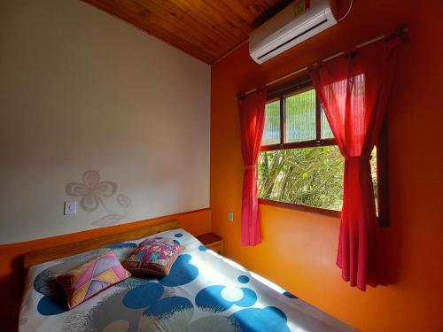a bedroom with a bed and a window at Morada Caminho do Mar in Praia do Rosa