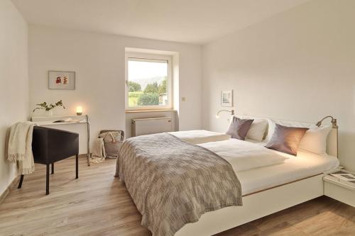 een slaapkamer met een bed, een bureau en een raam bij Ferienwohnung Hasport in Piesport