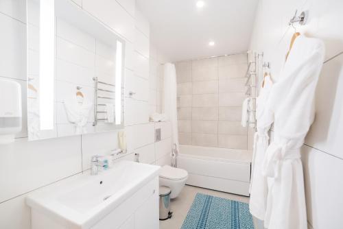 a white bathroom with a sink and a toilet at Solutel Apartments-35 in Bishkek