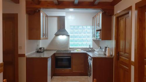 a kitchen with a sink and a stove top oven at Apartamentos El Haya in Cosgaya