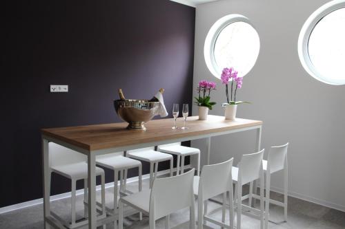 a dining room with a wooden table and white chairs at SCOTTY & PAUL Hotel Deggendorf in Deggendorf