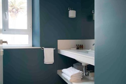 a blue bathroom with a sink and a mirror at Villa delle Palme in Santa Marinella