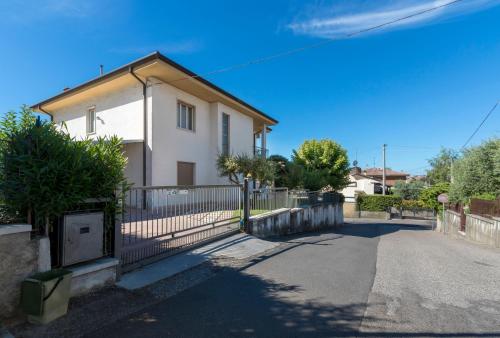 a white house with a fence next to a street at La Maison de Mely with garden in Sandra