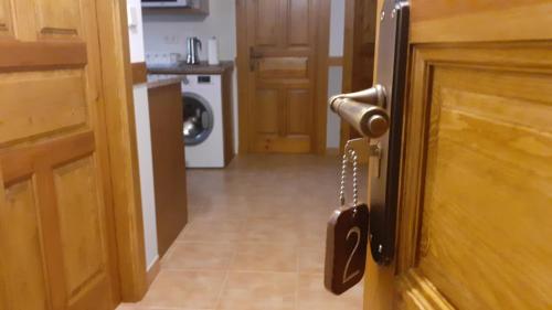 an open door to a kitchen with a washer at Apartamentos El Haya in Cosgaya