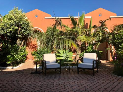un patio con mesa y sillas y un edificio en Hotel Madreselva, en Los Caños de Meca