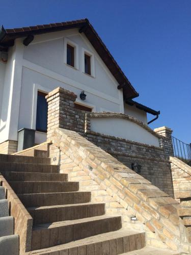 a white house with stairs leading up to it at Vass-Villa Vendégház in Szekszárd