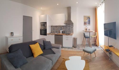 Una sala de estar con un sofá y una cocina. en Cosystudio centre Ajaccio, en Ajaccio