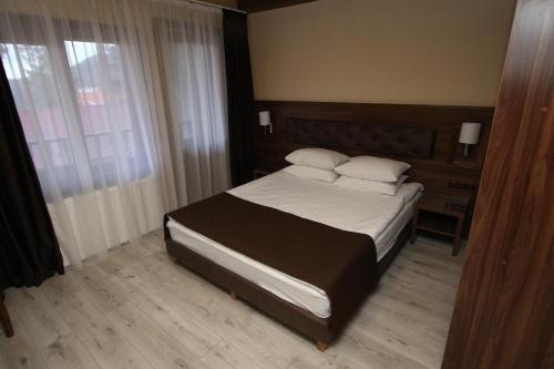 a bedroom with a bed with white sheets and pillows at BAYKA - SPA resort in Kosiv