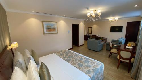 a bedroom with a bed and a living room at Sarova Woodlands Hotel and Spa in Nakuru