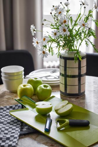 a table with green apples and a vase with flowers at Base Lausanne in Lausanne