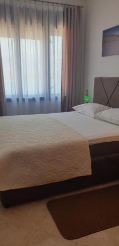 a large bed in a bedroom with a window at Apartments Klakor PS in Tivat