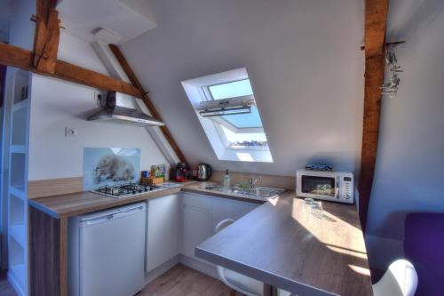 une cuisine avec des armoires blanches et une fenêtre dans l'établissement Rêves Bleus - Côte de Granit Rose, à Ploubezre