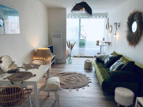 un salon avec un canapé vert et une table dans l'établissement Studio Le Surfing de Carnon plage, à Carnon-Plage