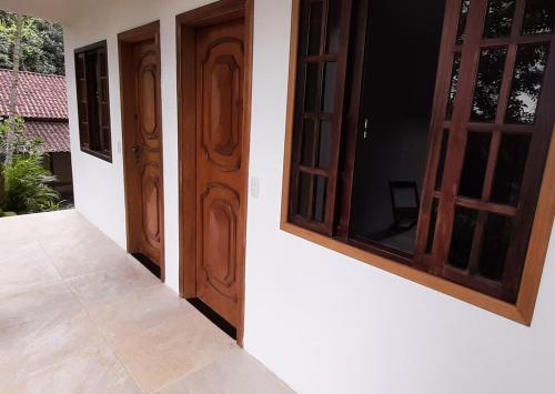 a pair of doors on the side of a house at Ilha Suites - Vila do Abraão in Abraão