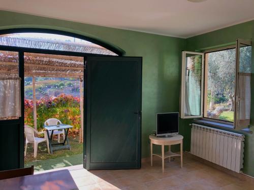 サンレモにあるAgriturismo Fattoria Attiva di Bigio Mauroの緑の部屋(ドア、テーブル、テレビ付)