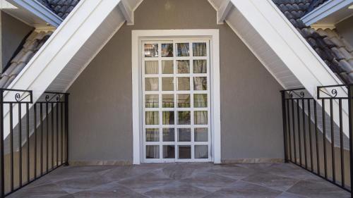 a glass door in a building with stairs at Village de Charme - 2km do Capivari in Campos do Jordão