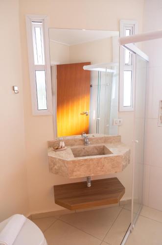 a bathroom with a sink and a mirror at Village de Charme - 2km do Capivari in Campos do Jordão