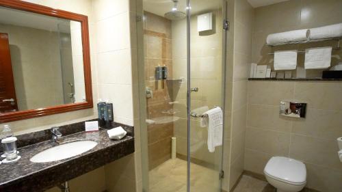 a bathroom with a shower and a sink and a toilet at Sarova Woodlands Hotel and Spa in Nakuru
