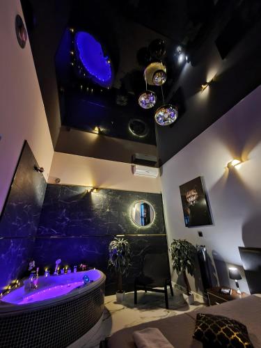 a room with a bath tub with purple lighting at Apartament z jacuzzi Kraków in Krakow
