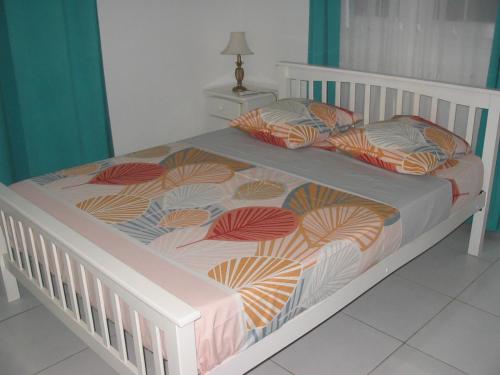 a white bed with two pillows on it at PETIT PARADIS in Quartier Morne la Valeur