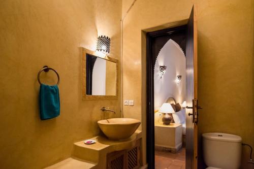 a bathroom with a bowl sink and a toilet at Riad Al Tainam in Marrakesh
