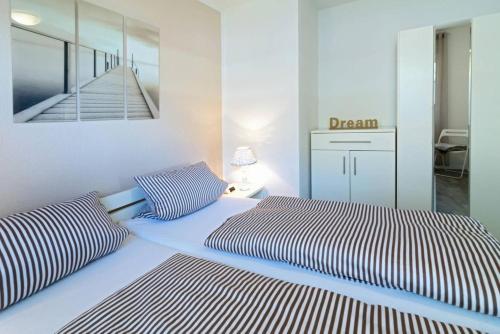 ein Schlafzimmer mit 2 Betten und ein Schild, das Traum liest in der Unterkunft Ferienwohnung Herzmuschel in Norddeich