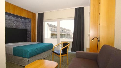 a hotel room with a bed and a couch and a window at nur 100 m bis zum Strand Appartmentanlage Eldena FeWo 15 in Lobbe