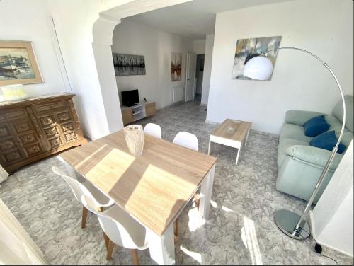 ein Wohnzimmer mit einem Holztisch und einer Couch in der Unterkunft Apartamento Marbella centro con piscina in Marbella