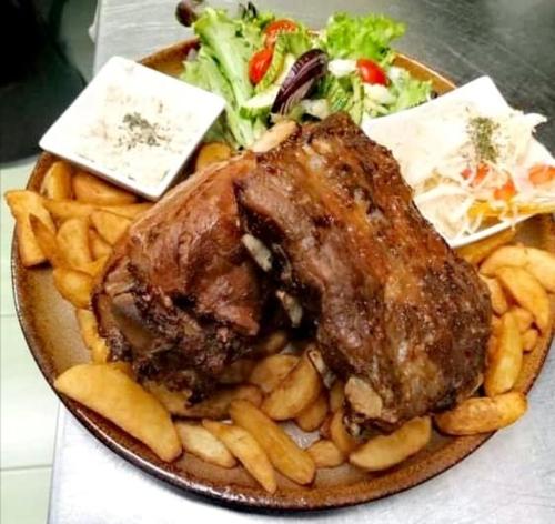 a plate of food with meat and fries and a salad at Jolán Pension & Restaurant in Číčov