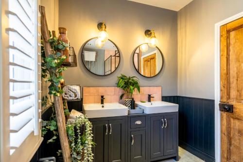 a bathroom with two sinks and two mirrors at 46 Nunnery Lane in York