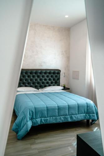 a bedroom with a bed with a blue bedspread at Hotel Bruman Salerno in Salerno