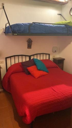 a bedroom with a red bed with a red blanket at Casa Nicoletta in Sarteano