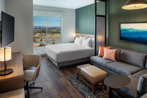 a hotel room with a bed and a couch at Hyatt Place Harrisonburg in Harrisonburg