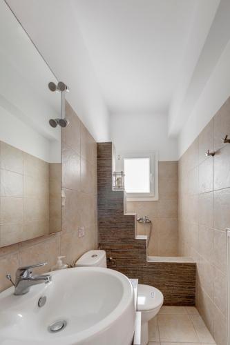 a bathroom with a sink and a toilet and a staircase at Endless Blue from Syros - Fabrika House 1 & 2 in Vári