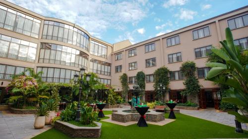 an apartment building with a courtyard with plants at Sarova Woodlands Hotel and Spa in Nakuru