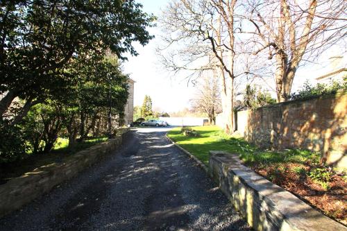 a road with a fence and trees on the side at Beautiful 2 to 3 bed apartment with stunning views! in Ayr