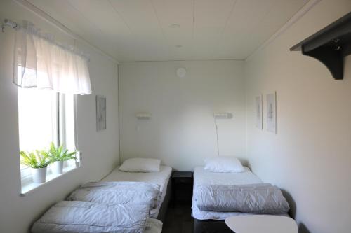 two beds in a room with a window at Kärraton Stugor in Åhus
