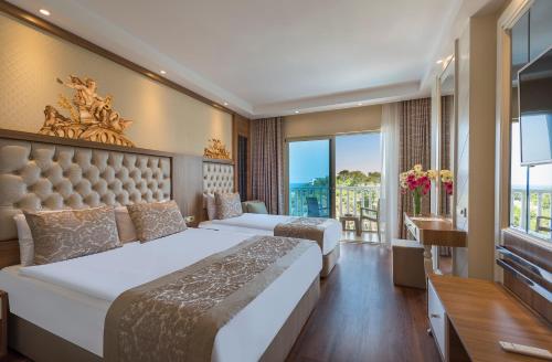 a hotel room with two beds and a balcony at Oz Hotels Sui in Alanya