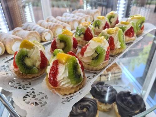 a display case filled with pastries with fruit on them at Jolán Pension & Restaurant in Číčov