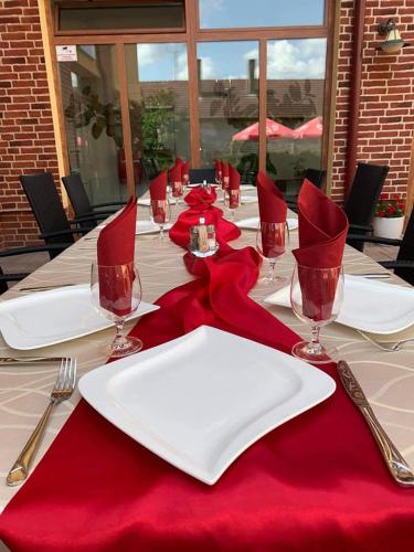 a long table with red napkins and glasses on it at Jolán Pension & Restaurant in Číčov