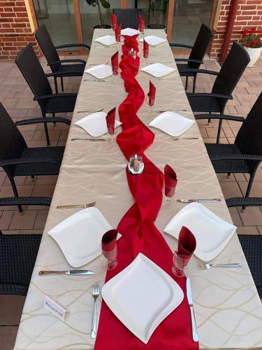 a long table with red napkins and wine glasses on it at Jolán Pension & Restaurant in Číčov