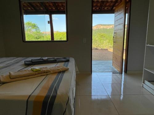 1 dormitorio con cama y ventana con vistas en Casa Barreirinho Parque Nacional Serra da Capivara en Coronel José Diaz