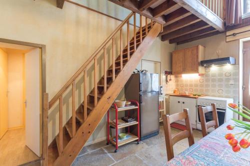 une cuisine avec un escalier en bois dans l'établissement Le Caméléon, à Corgoloin