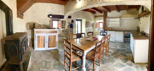 a large kitchen with a wooden table and chairs at Bedousses in Aujac