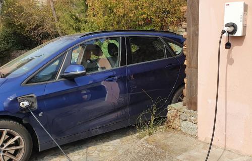 a blue car is parked in front of a window at La vie est belle in Finale Ligure
