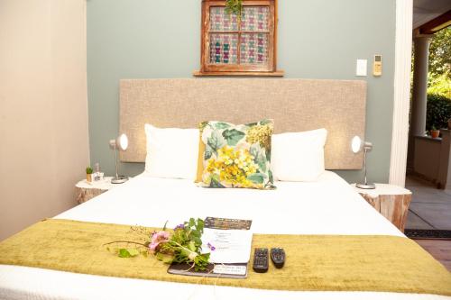 a bedroom with a white bed with flowers on it at De Akker Guest House Oudtshoorn in Oudtshoorn