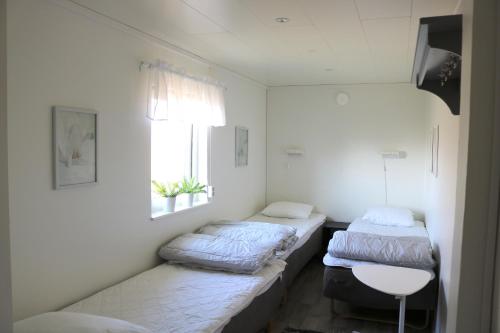 two beds sitting in a room with a window at Kärraton Stugor in Åhus