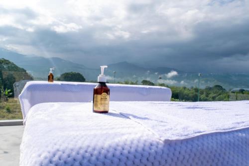 a bottle of alcohol sitting on top of a bed at Chalet La Alemania in Calarcá