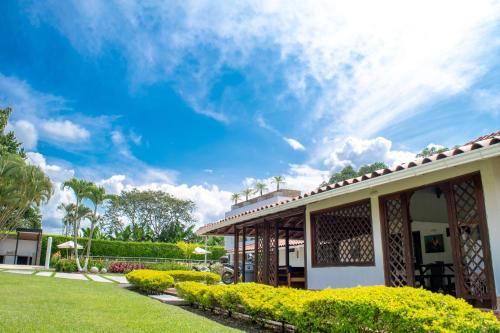 a house with a garden and a blue sky at Chalet La Alemania in Calarcá